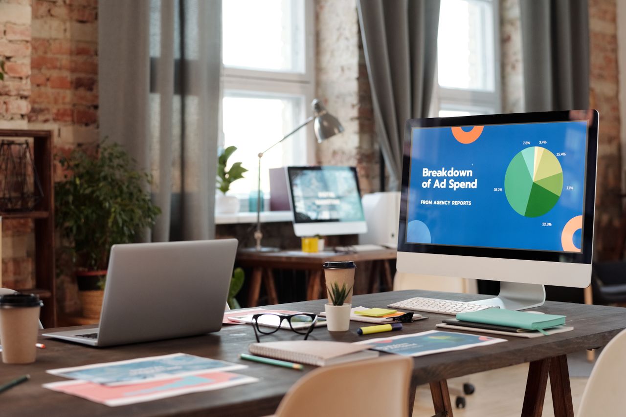 Un espace de travail de bureau moderne avec des ordinateurs, des graphiques et du matériel de bureau pour un environnement productif.